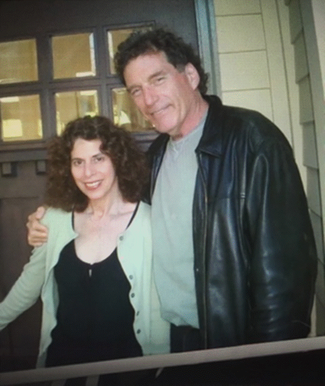 Two people standing in front of a window Description automatically generated