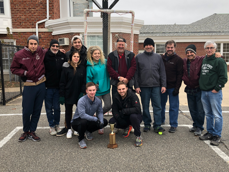 A group of people standing in front of a building
Description automatically generated