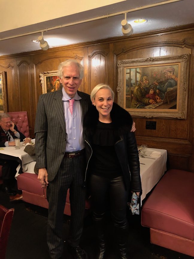 Two people standing in a room
Description automatically generated