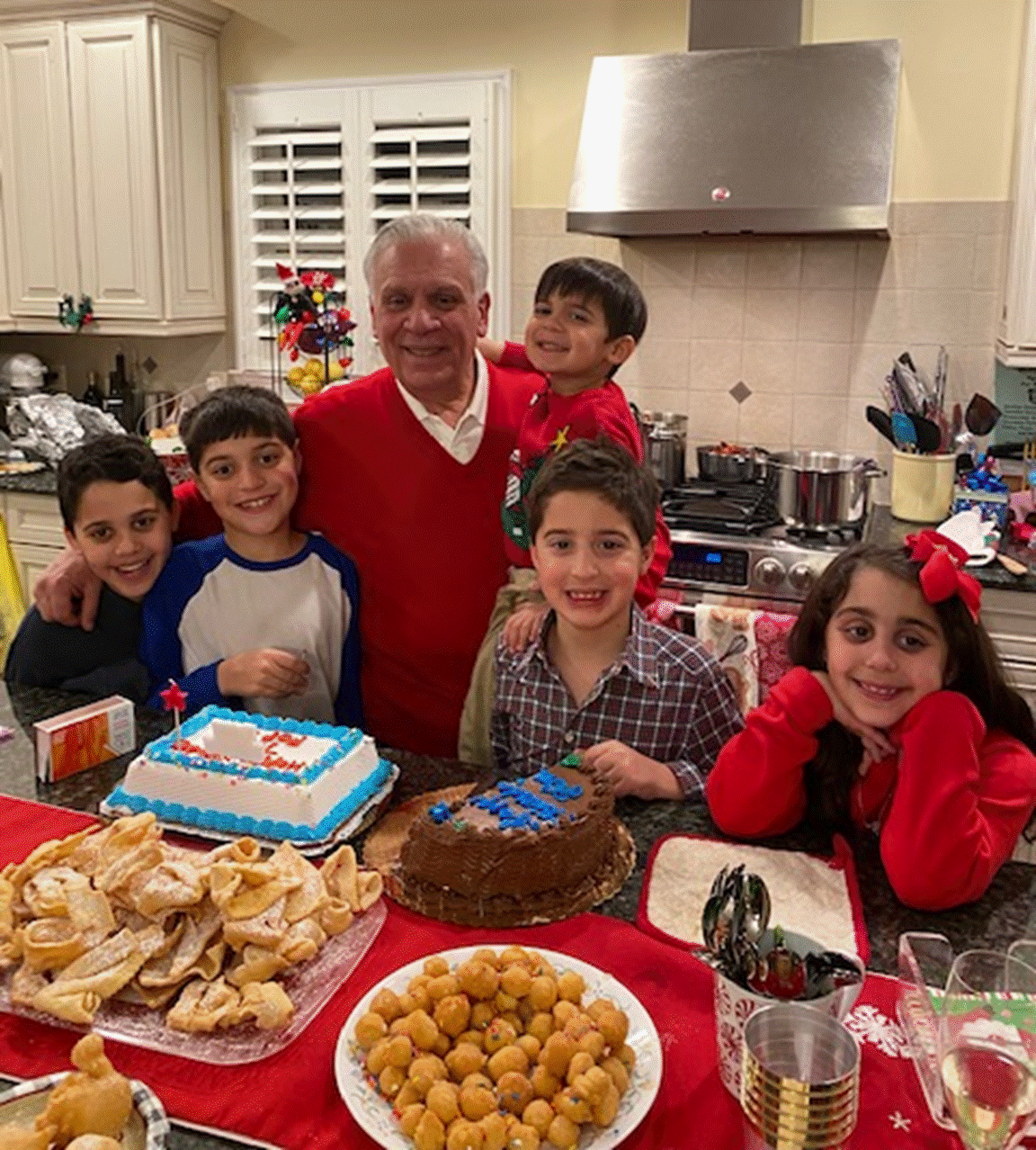 A group of people standing in a kitchen

Description automatically generated