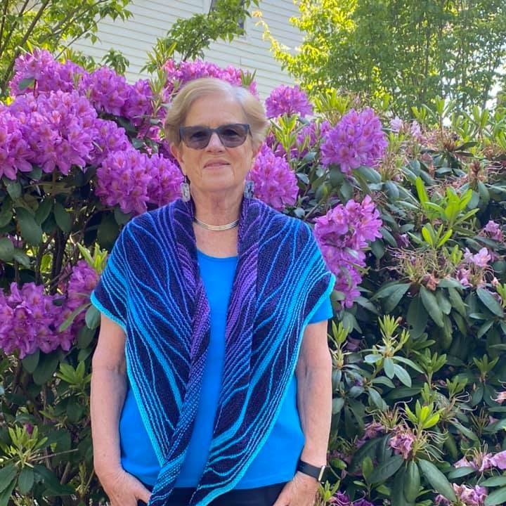 A person wearing a purple flowerDescription automatically generated