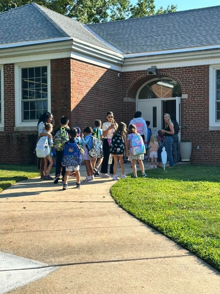 Students and adults at school entrance.